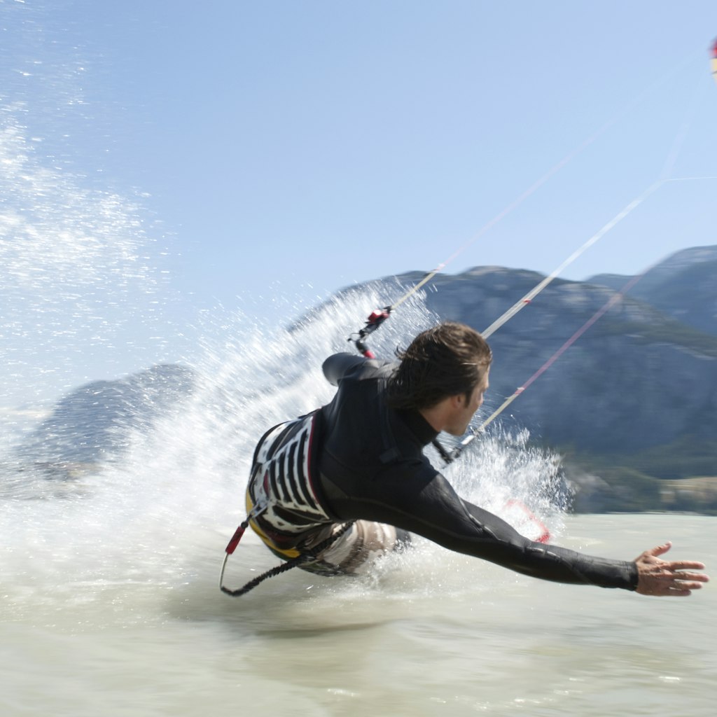 man kiteboarding, on water