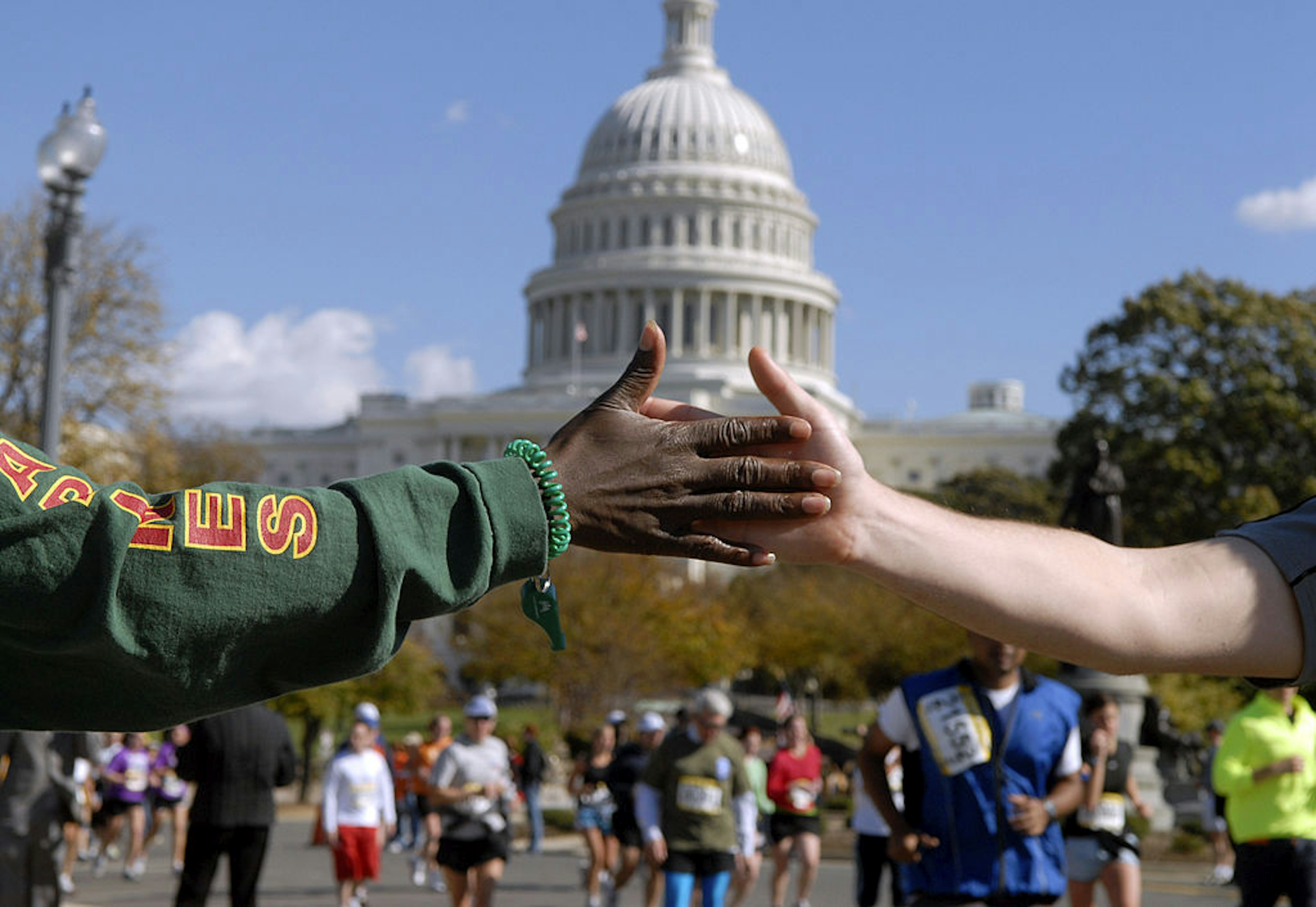 UNITED STATES - OCTOBER 29:  JoAnn Thomas of the District, encourages a runner in the 31st Marine Corps Marathon as they pass the west front of the Capitol.  (Photo By Tom Williams/Roll Call/Getty Images)