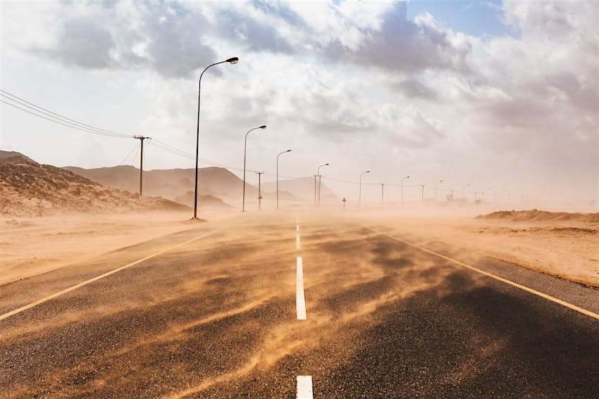 Le sable souffle sur une route lors d'une tempête de sable à Ras al Hadd, Oman