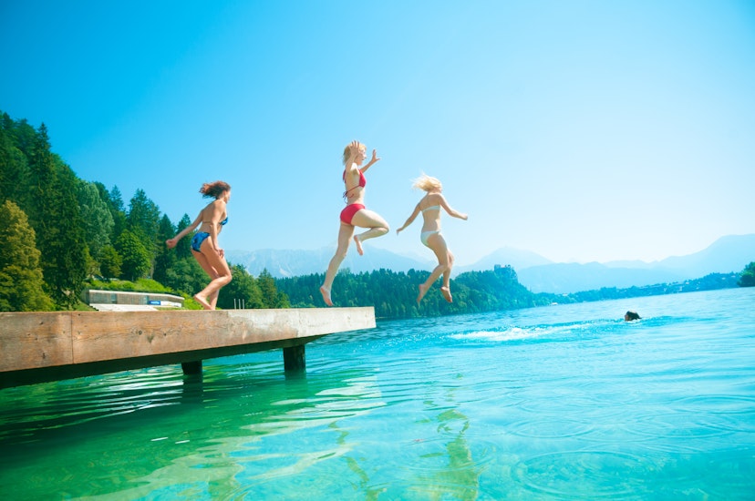 Teenage girls jumping from pier in the lake. Bled. Slovenia