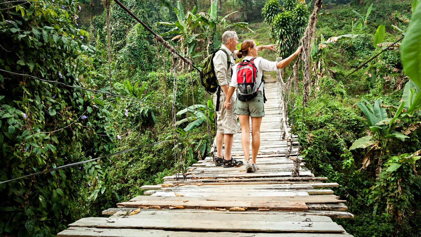 Couple with backpack hiking in rainforest