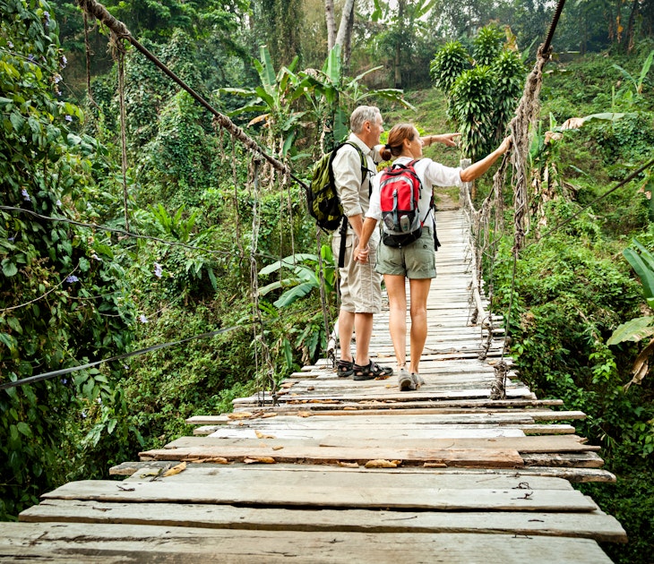 Couple with backpack hiking in rainforest