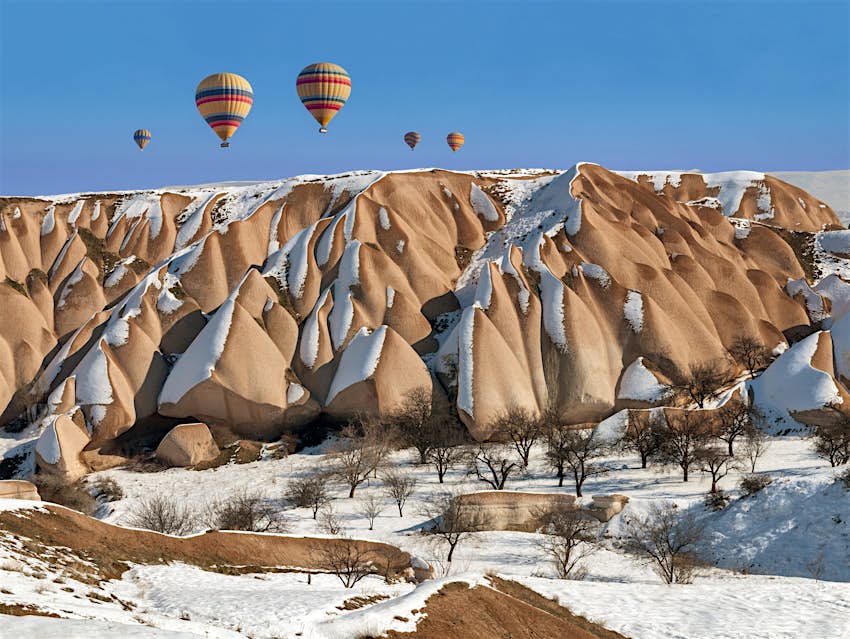 Kapadokya, Türkiye'nin karla kaplı dağlarında yüzen sıcak hava balonu