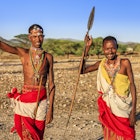 African warriors from Samburu tribe standing on savanna and holding a spears, central Kenya. Samburu tribe is one of the biggest tribes of north-central Kenya, and they are related to the Maasai.