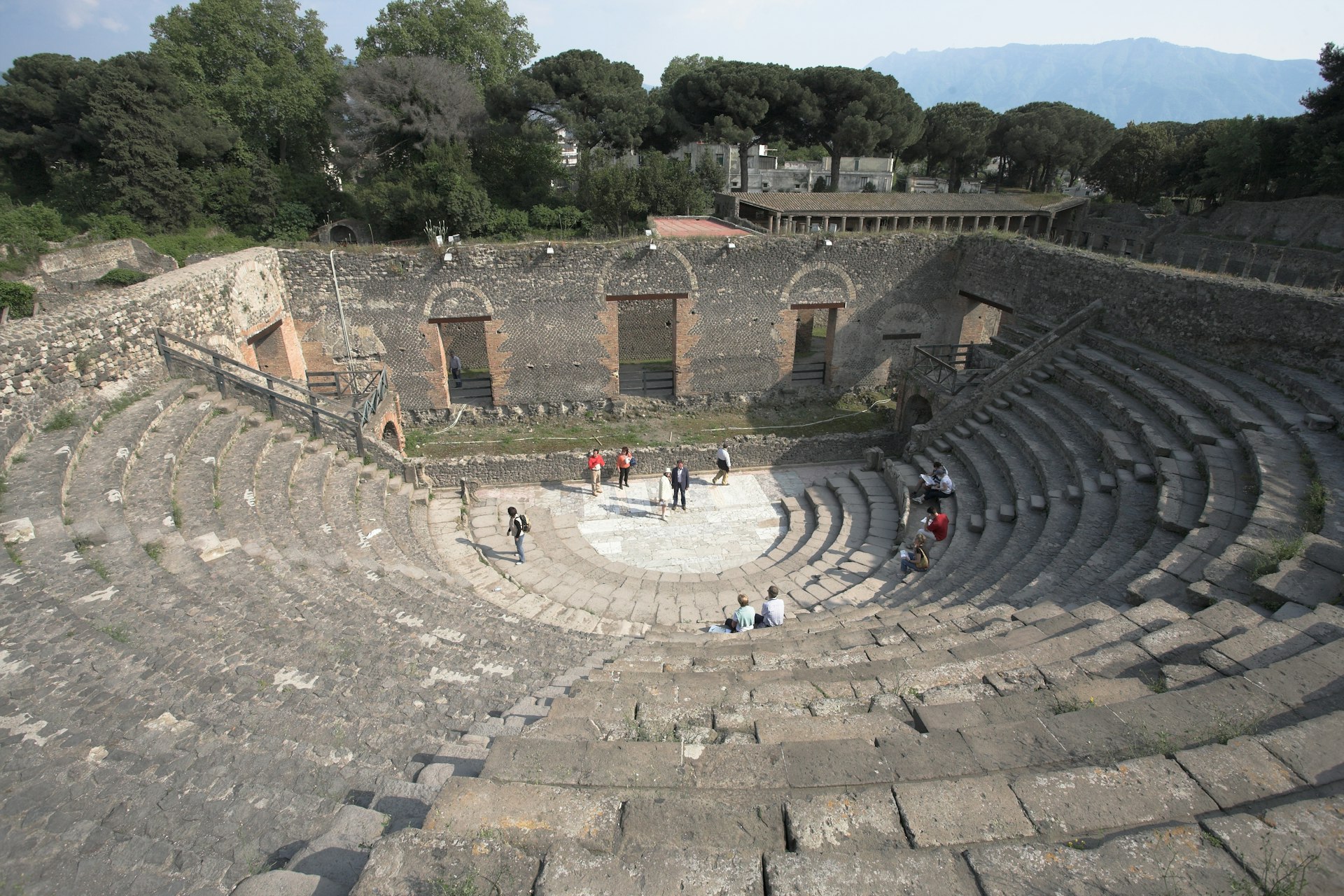 Visitors on the stone stage of Pompeii Theatre