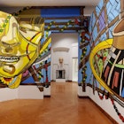 A colorful display in the foreground frames a bust in the room beyond