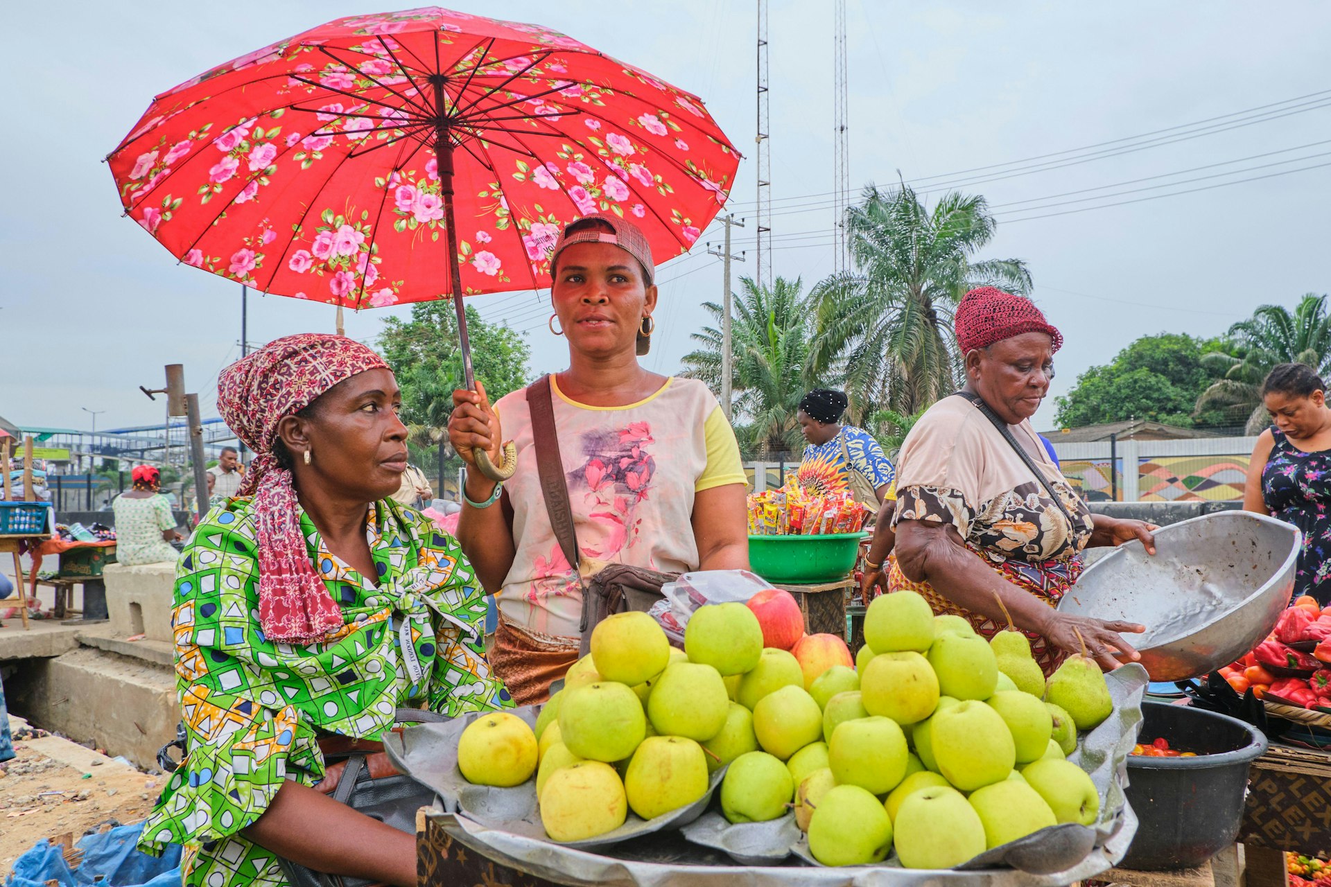 Traders selling apples and vegetables at a market in Lagos, Nigeria.