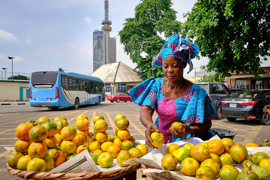Straßenverkäufer verkauft Orangen in den Straßen der Innenstadt von Lagos.