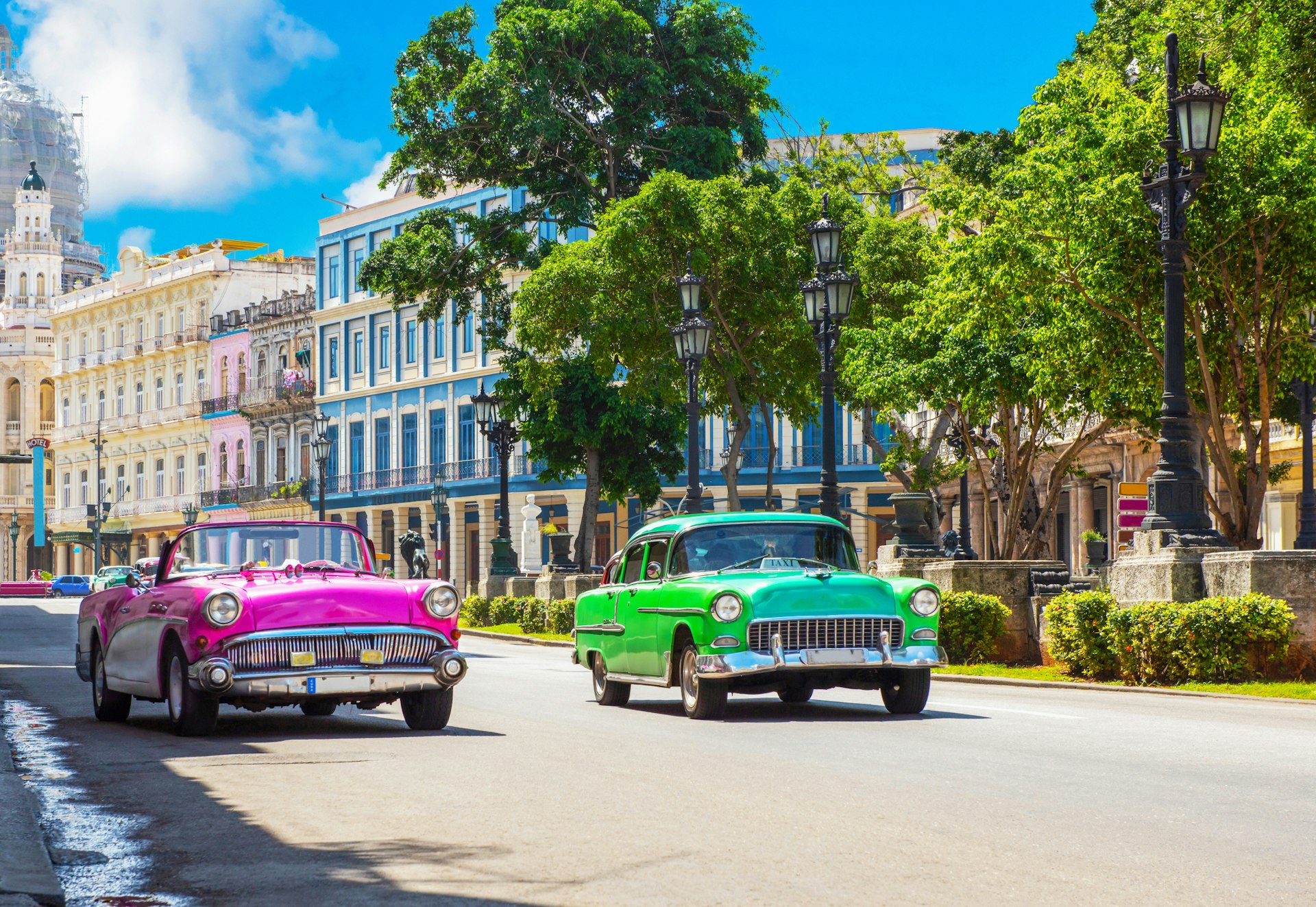 Cityscape with american pink and green 1950-1959 vintage cars on the main street Paseo Jose Marti in Havana, Cuba