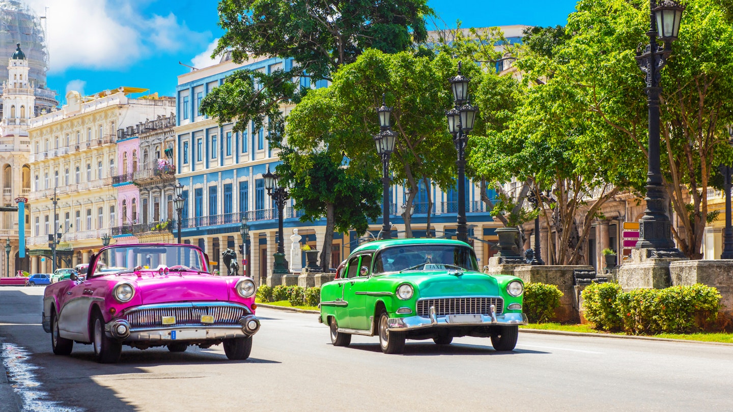 Cityscape with american pink and green 1950-1959 vintage cars on the main street Paseo Jose Marti in Havana City Cuba - Serie Cuba Reportage