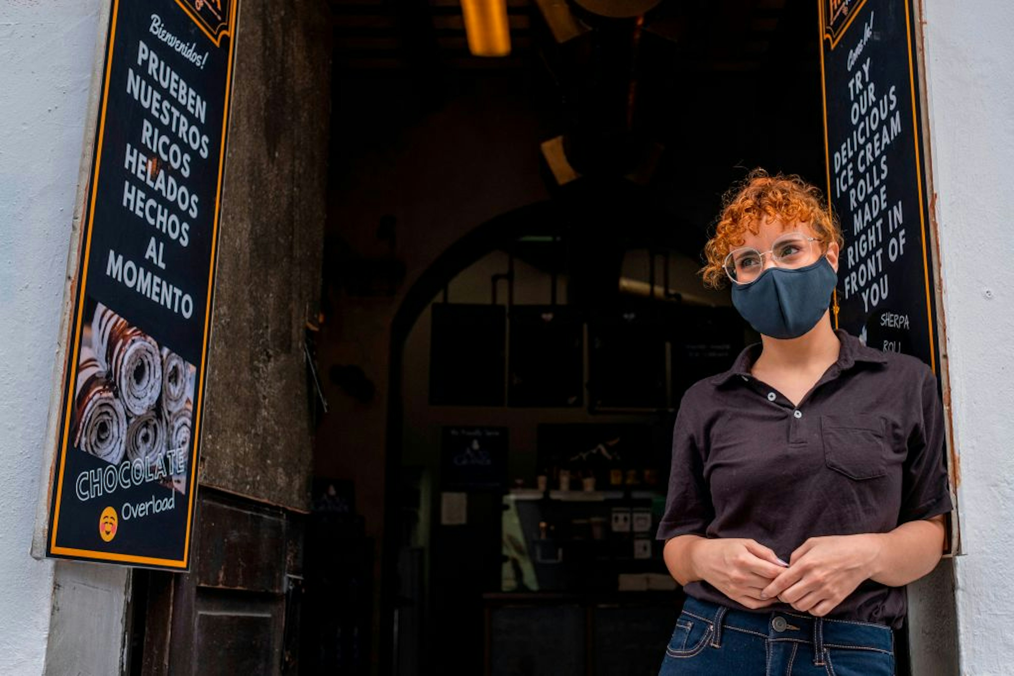 Restaurant hostess wearing a mask in front of a restaurant in Old San Juan