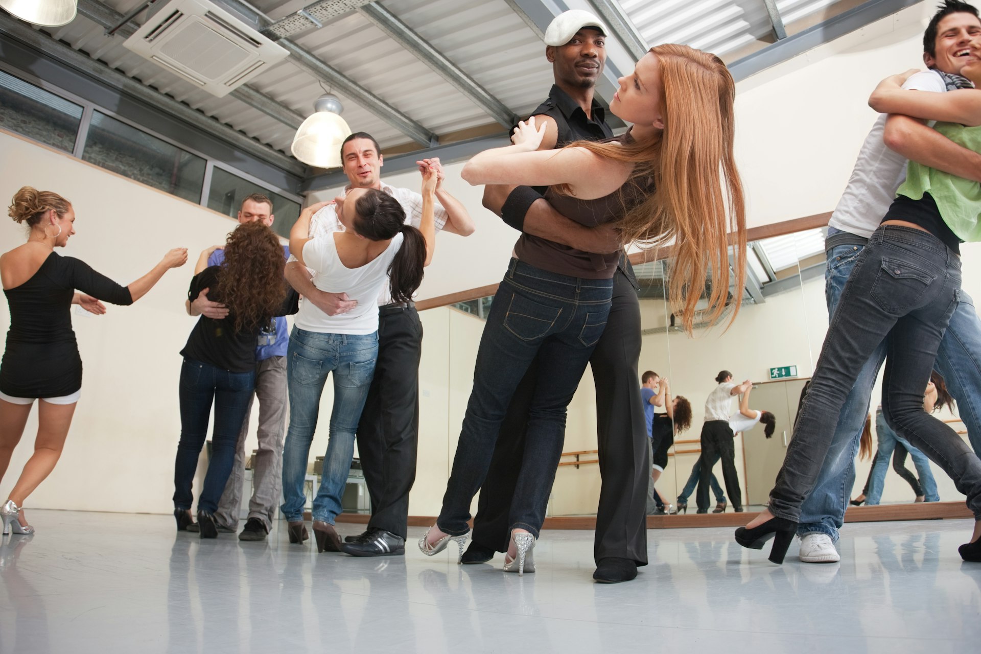 A group of people dance salsa during a class.