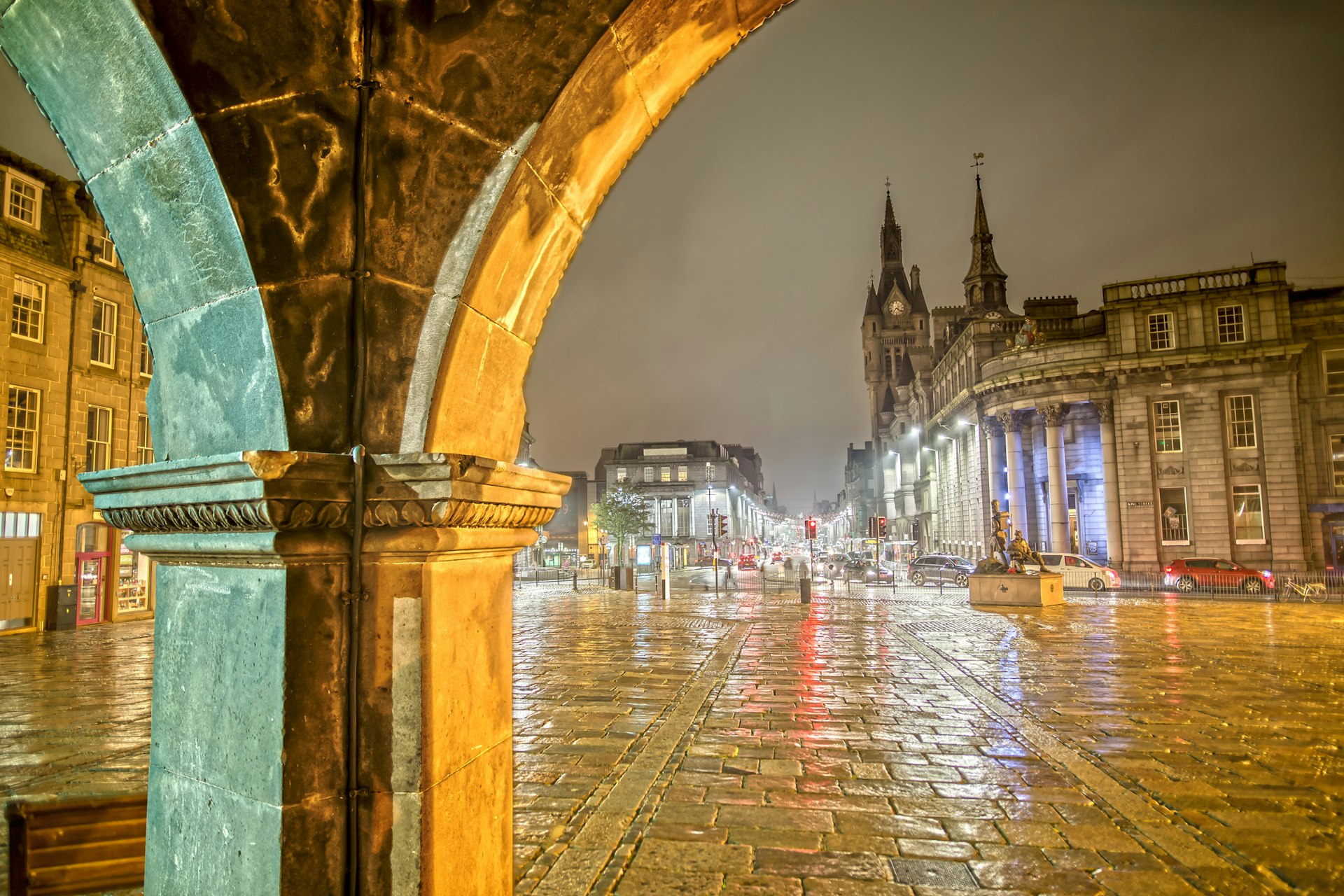 The rain-soaked cobbled streets of Aberdeen at night illuminated by street lights