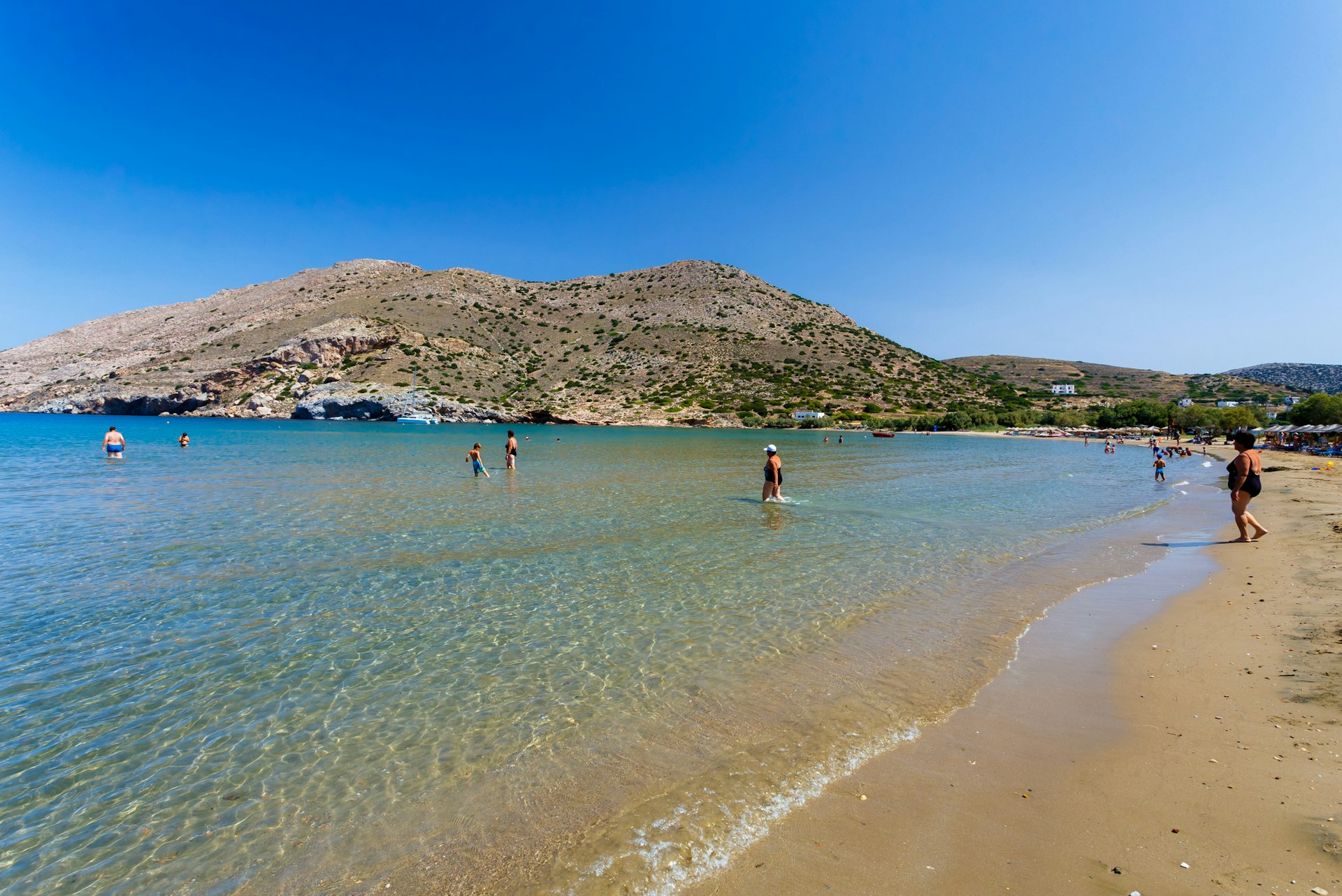 Beach of Galissas in Syros island, Greece against a clear blue sky. Galissas is one of the few sand beaches in Syros island