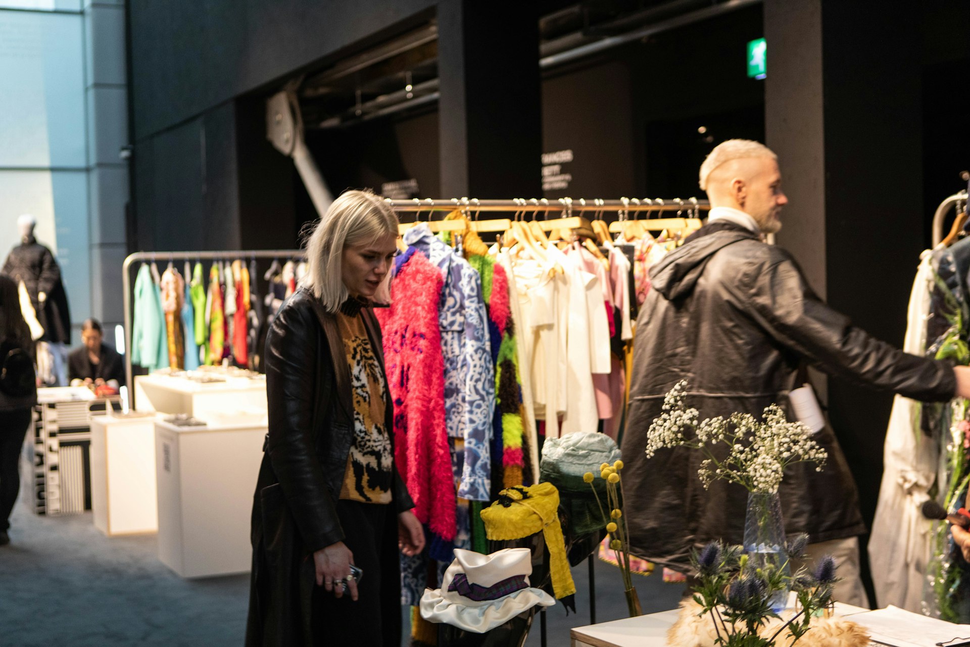 A woman browses through a rail of clothes at a fashion event