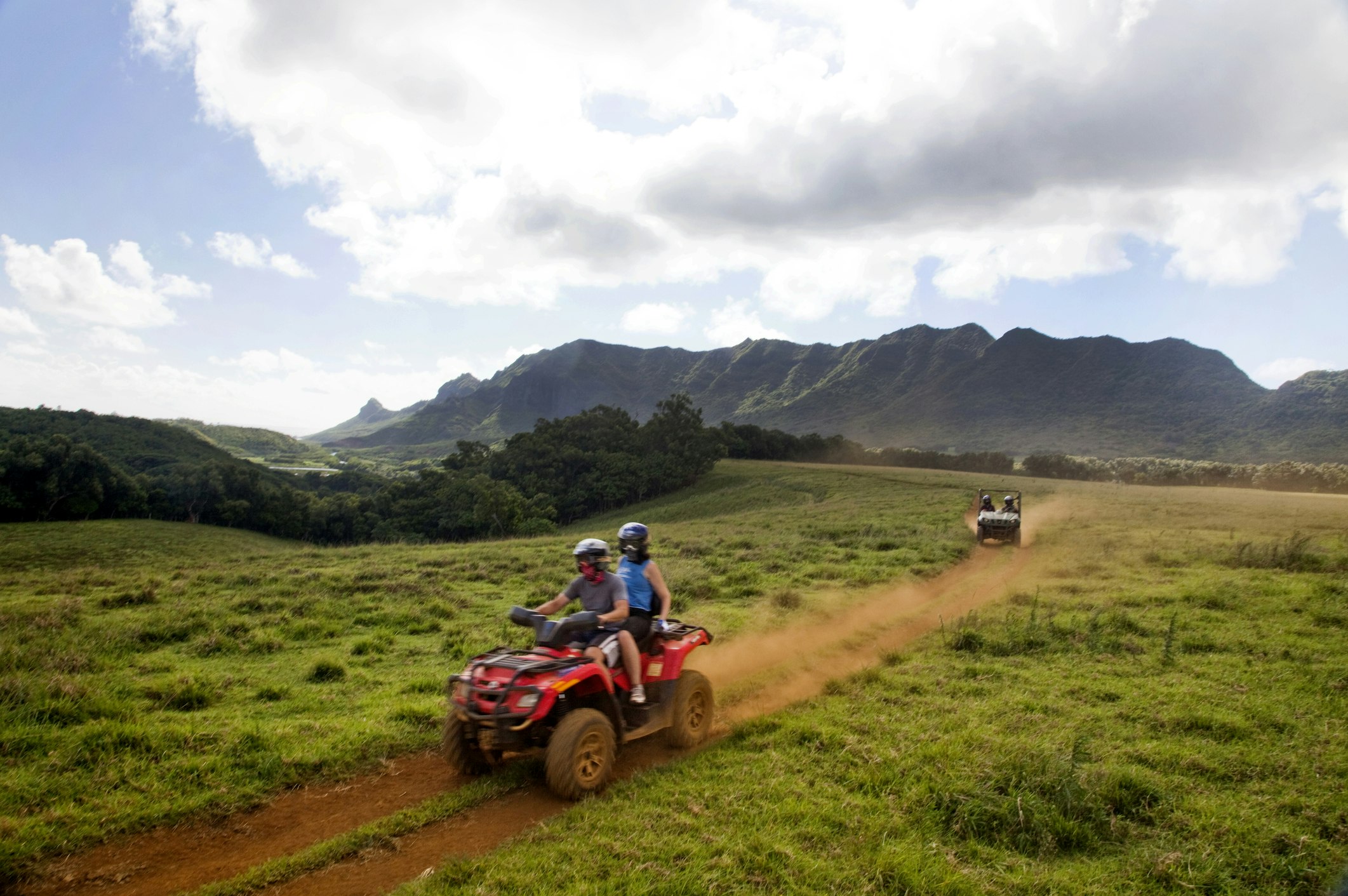 People exploring on all-terrain vehicle through a volcanic landscape
