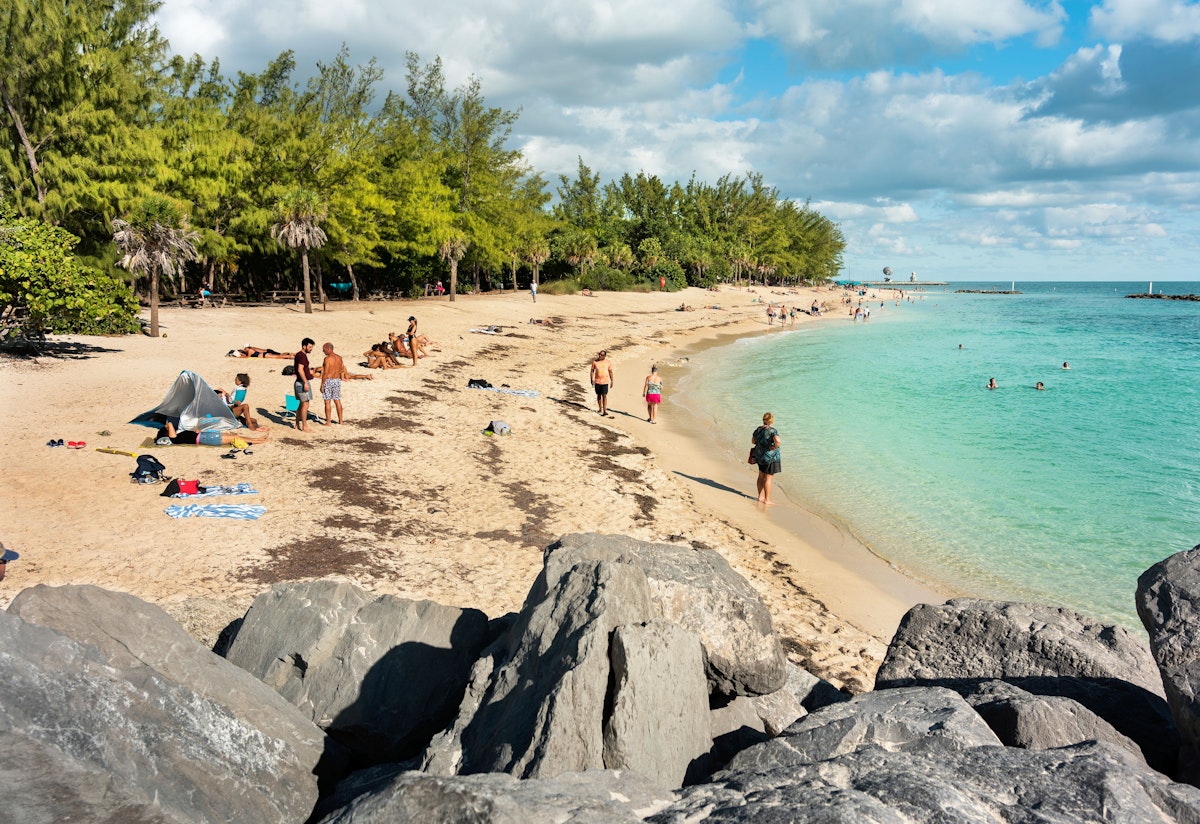 Key West, Florida - December 4, 2019:  People tan and rest on the sunny beach of Fort Zachary Taylor State Park in tropical Key West Florida USA