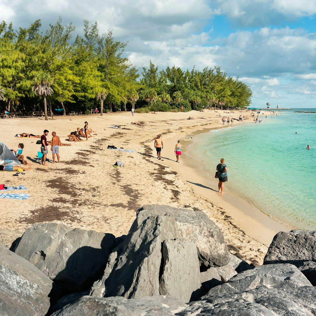 Key West, Florida - December 4, 2019:  People tan and rest on the sunny beach of Fort Zachary Taylor State Park in tropical Key West Florida USA