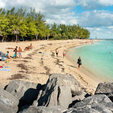 Key West, Florida - December 4, 2019: People tan and rest on the sunny beach of Fort Zachary Taylor State Park in tropical Key West Florida USA