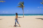 A woman walks on a beach in San Juan, Puerto Rico on a bright sunny day. 