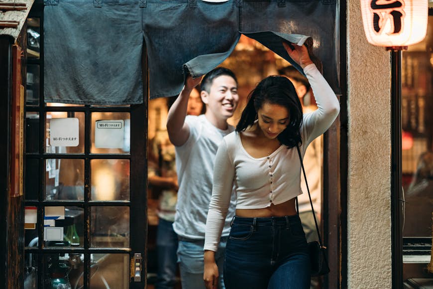 Young couple leaving restaurant in Tokyo