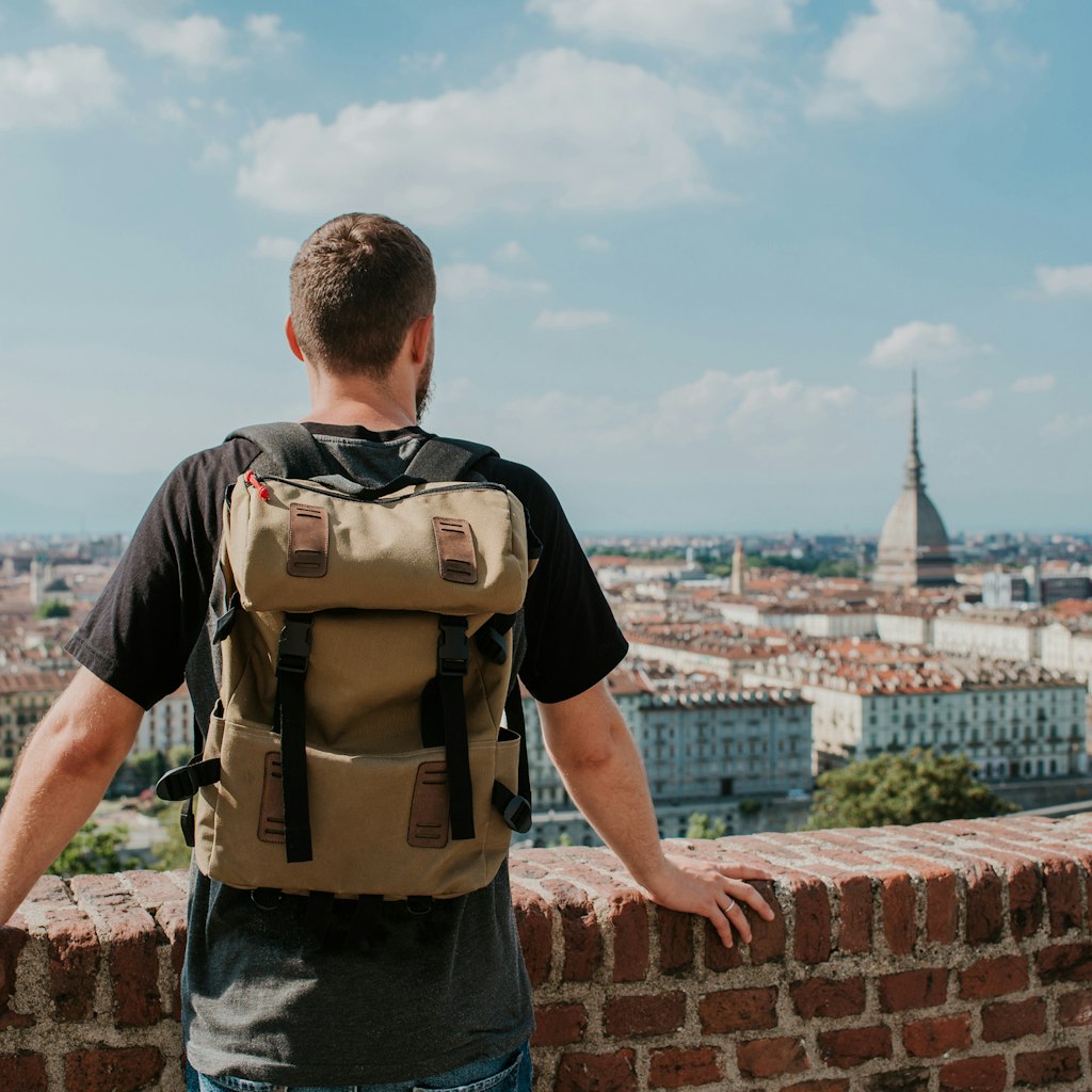 Man with backpack enjoy panorama of the Turin. Amazing scenic view on Mole Antonelliana