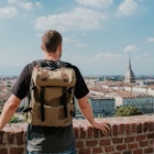 Man with backpack enjoy panorama of the Turin. Amazing scenic view on Mole Antonelliana