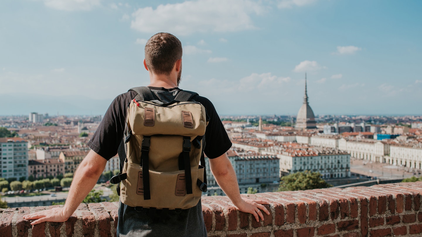 Man with backpack enjoy panorama of the Turin. Amazing scenic view on Mole Antonelliana