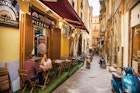 April 19, 2018: A couple eating pizza outside a pizzeria in the old city of Naples.