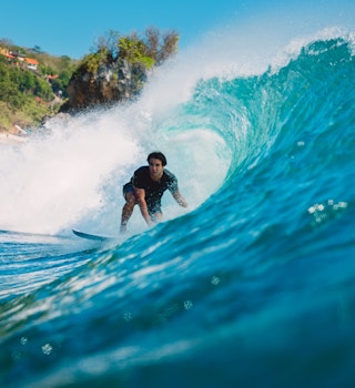 July 7, 2018: A male surfer inside the barrel of a wave at Padang Padang.