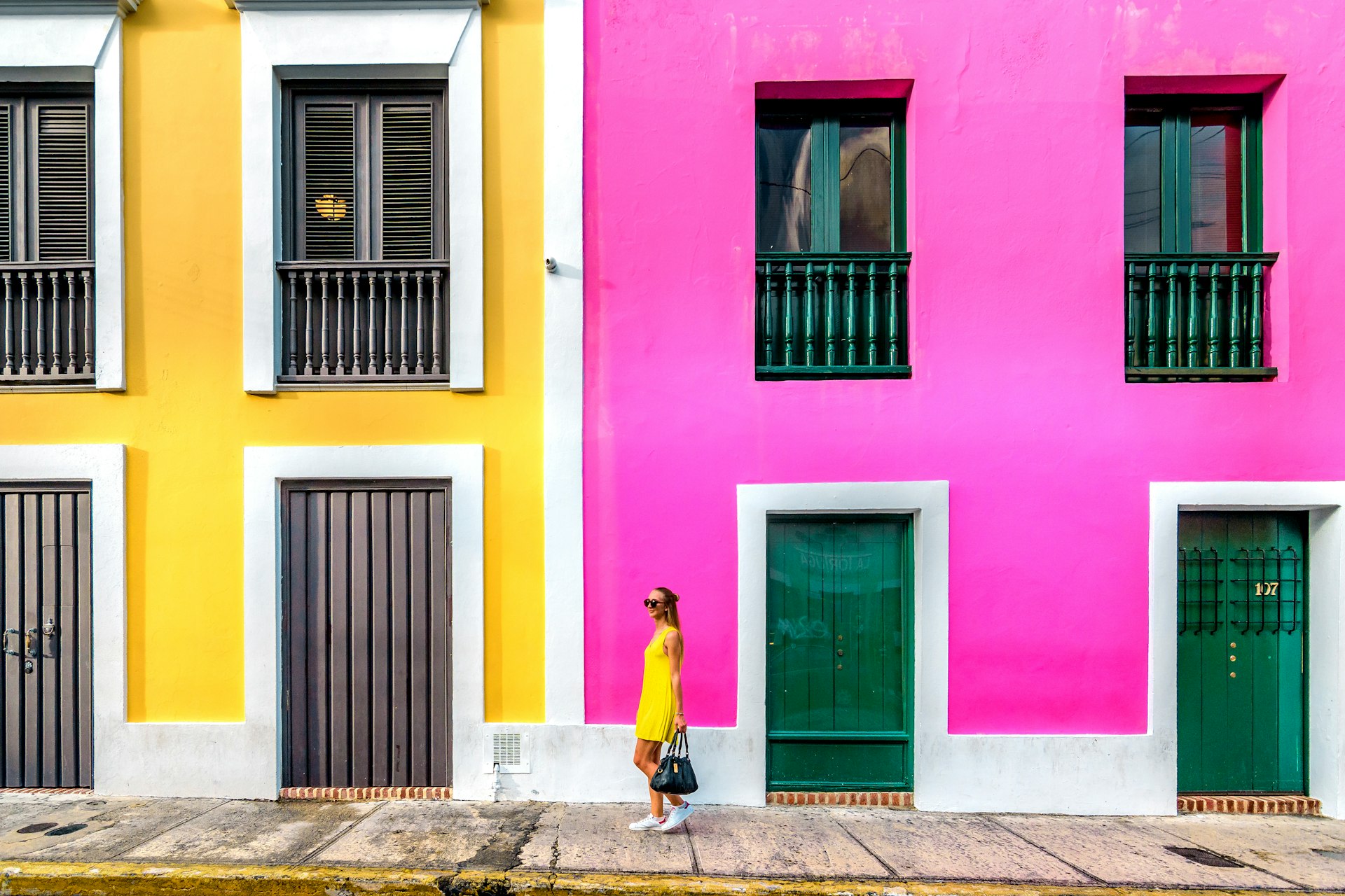 Woman in a yellow dress in front of colorful facades in Old San Juan