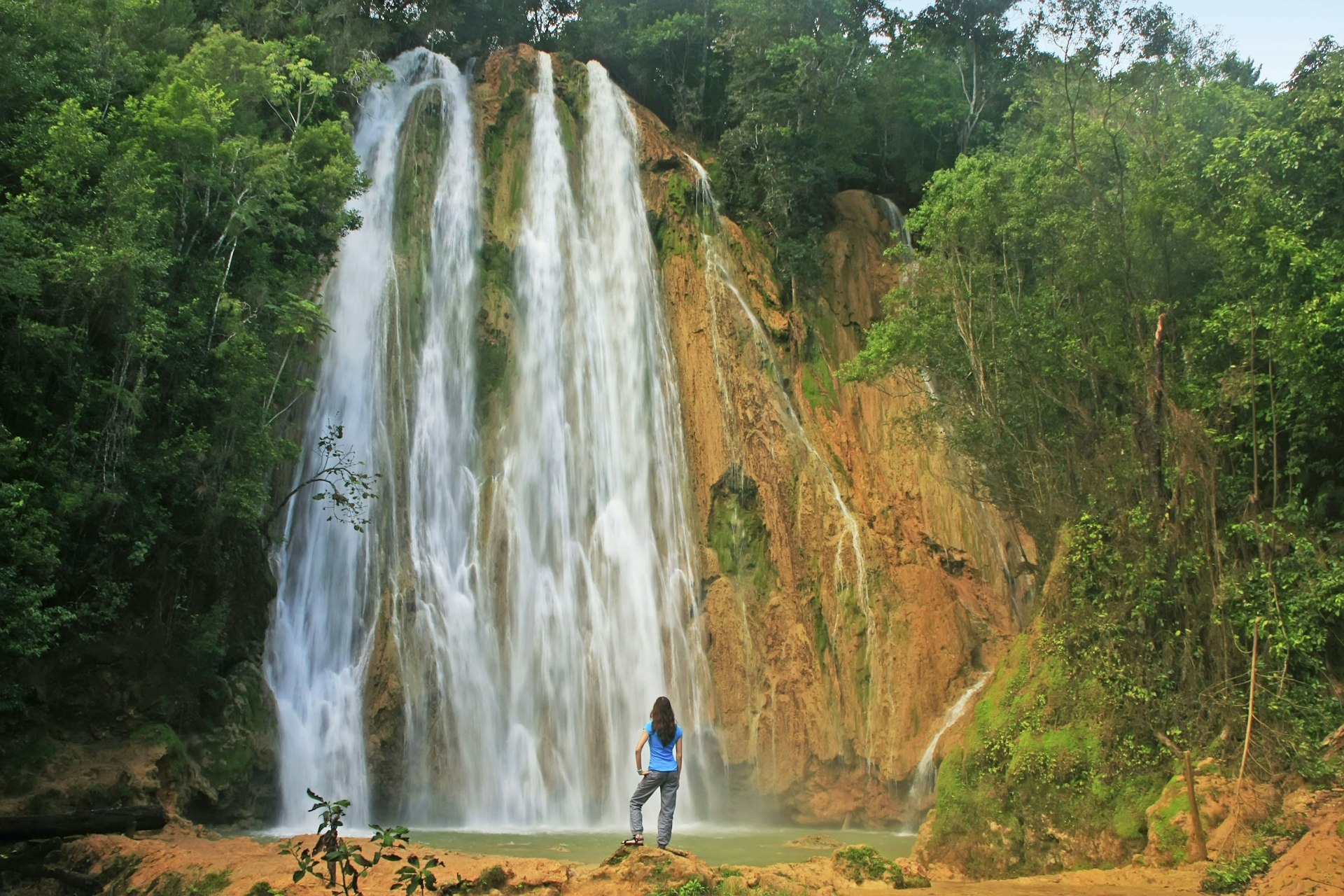 A woman standing in front of the cascading El Limón waterfall