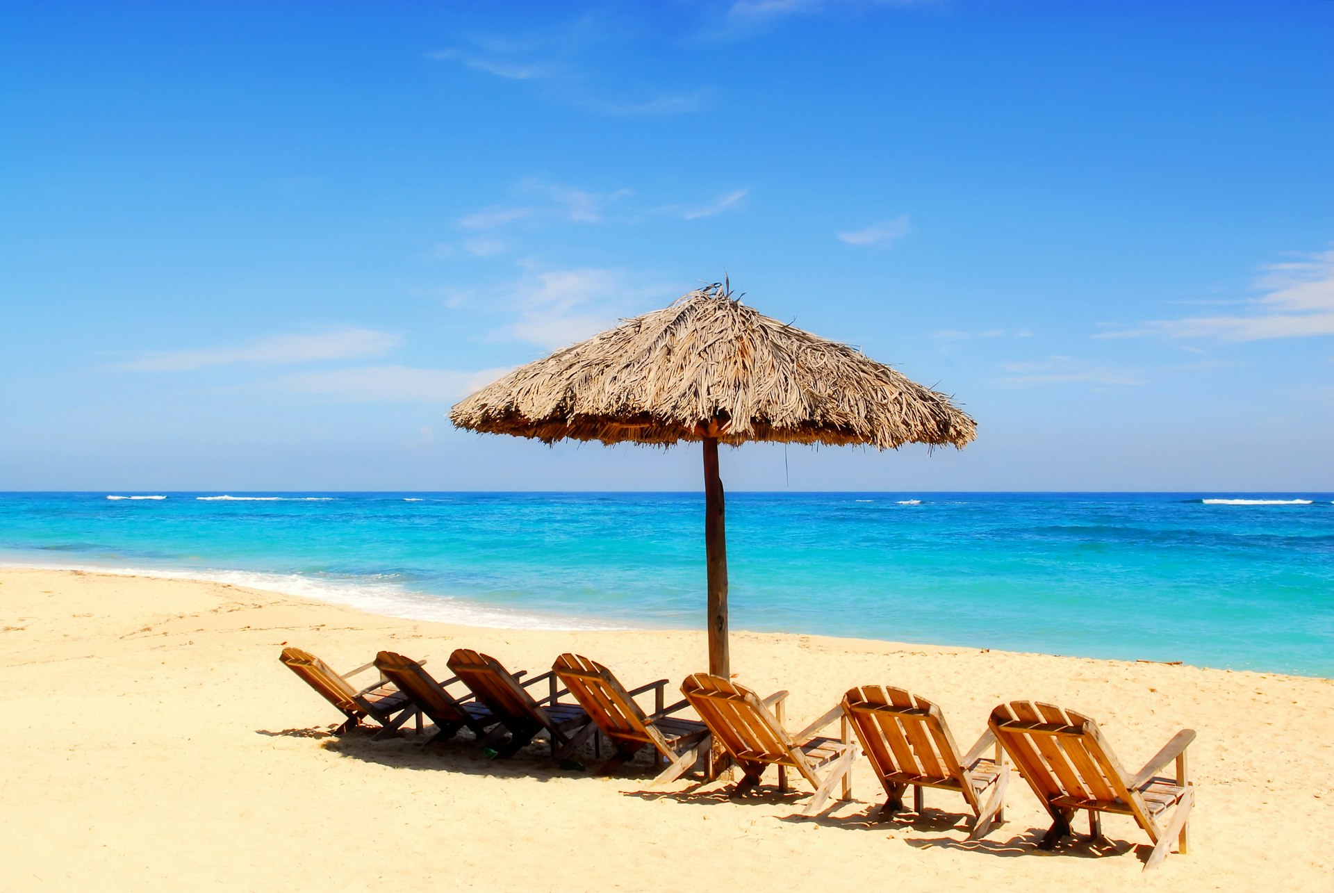 Umbrella and wooden chairs on a tropical Caribbean beach in Maguana Beach, Cuba