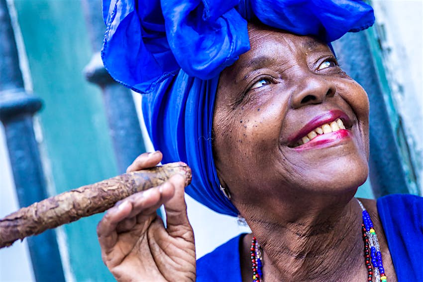 Portrait of an Afro-Cuban woman smoking cigar and smiling in Havana, Cuba