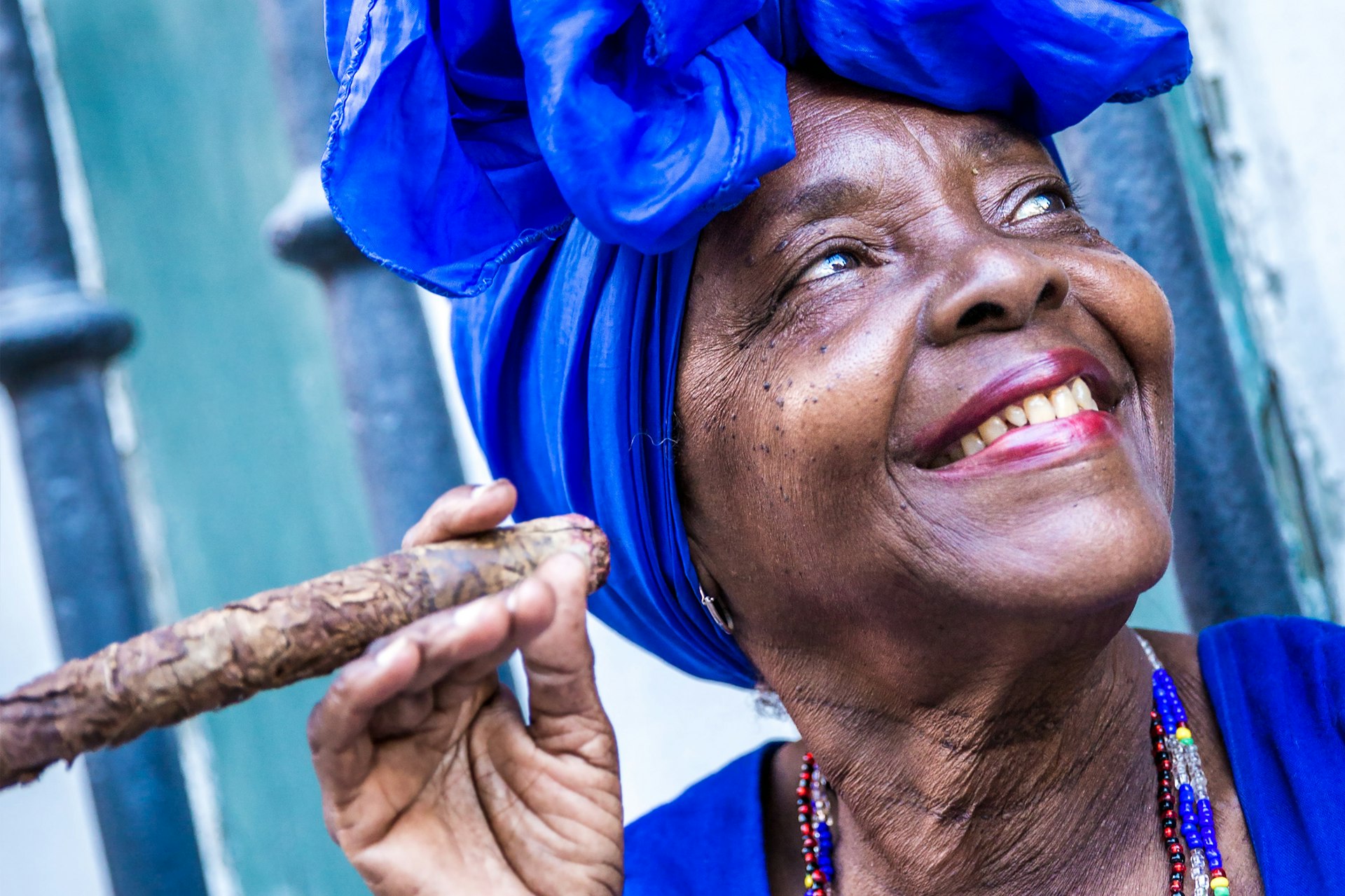 Portrait of an Afro-Cuban woman smoking cigar and smiling in Havana, Cuba