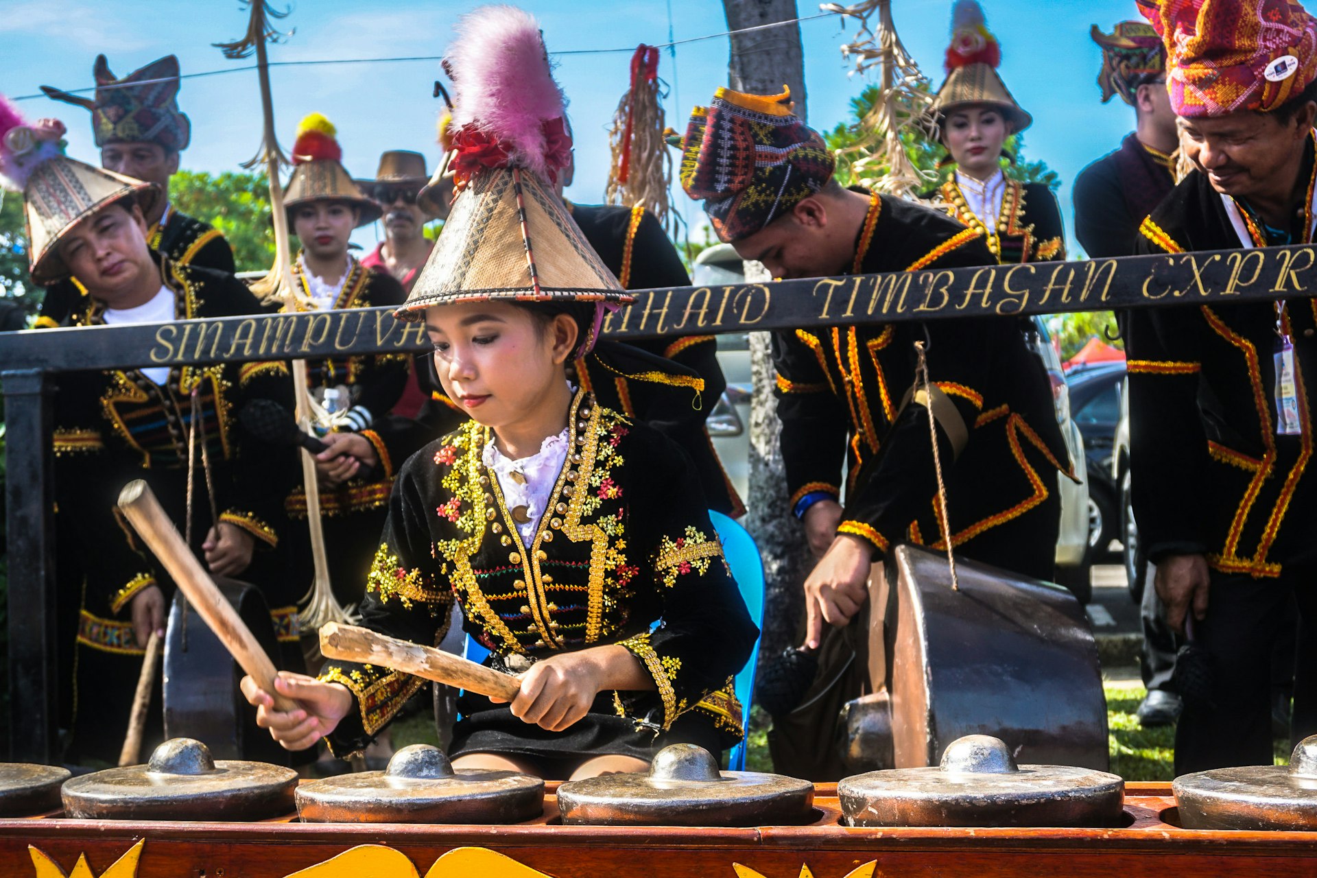 Girl from the Kadazandusun ethnic group playing a gong during the Sabah Harvest Festival