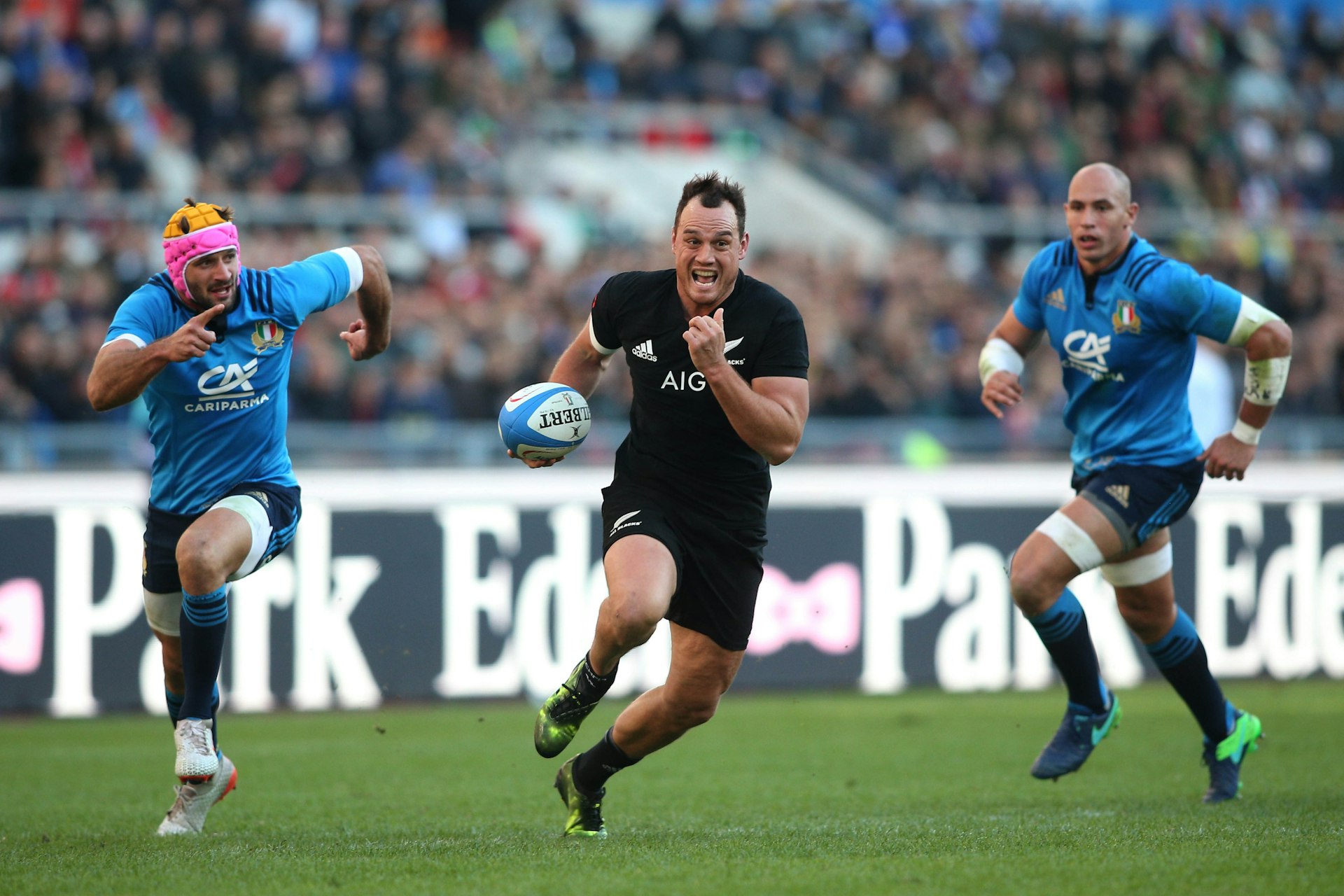 Rugby players on the field during a test match between Italy and New Zealand