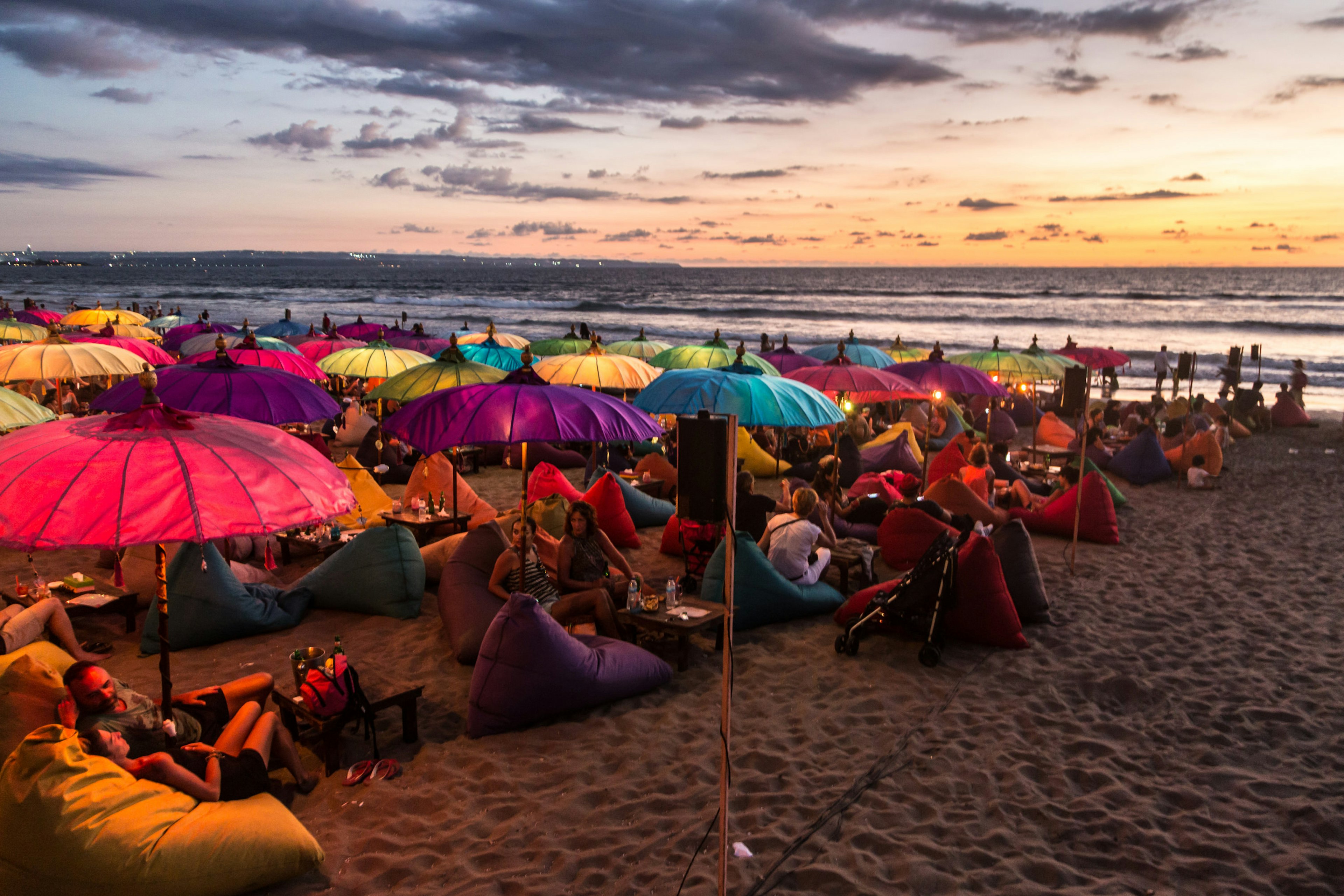 KUTA, INDONESIA - FEBRUARY 19, 2016: A large crowd of tourists enjoy the sunset at a bar on Kuta beach in Seminyak, Bali. The island is famous for its nightlife.