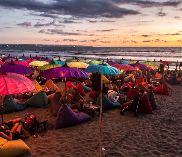 KUTA, INDONESIA - FEBRUARY 19, 2016: A large crowd of tourists enjoy the sunset at a bar on Kuta beach in Seminyak, Bali. The island is famous for its nightlife.