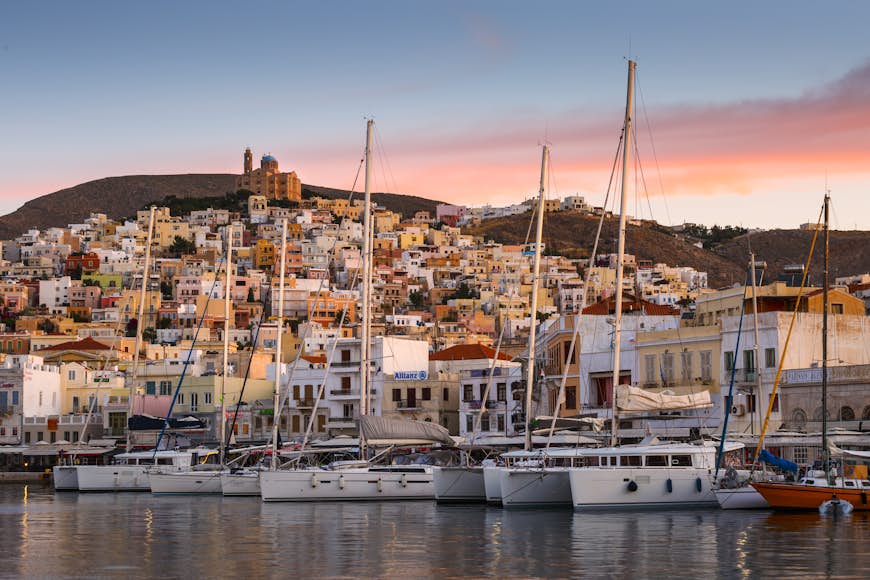 Staden Ermoupoli på ön Syros i Grekland med segelbåtar förlagda i viken
