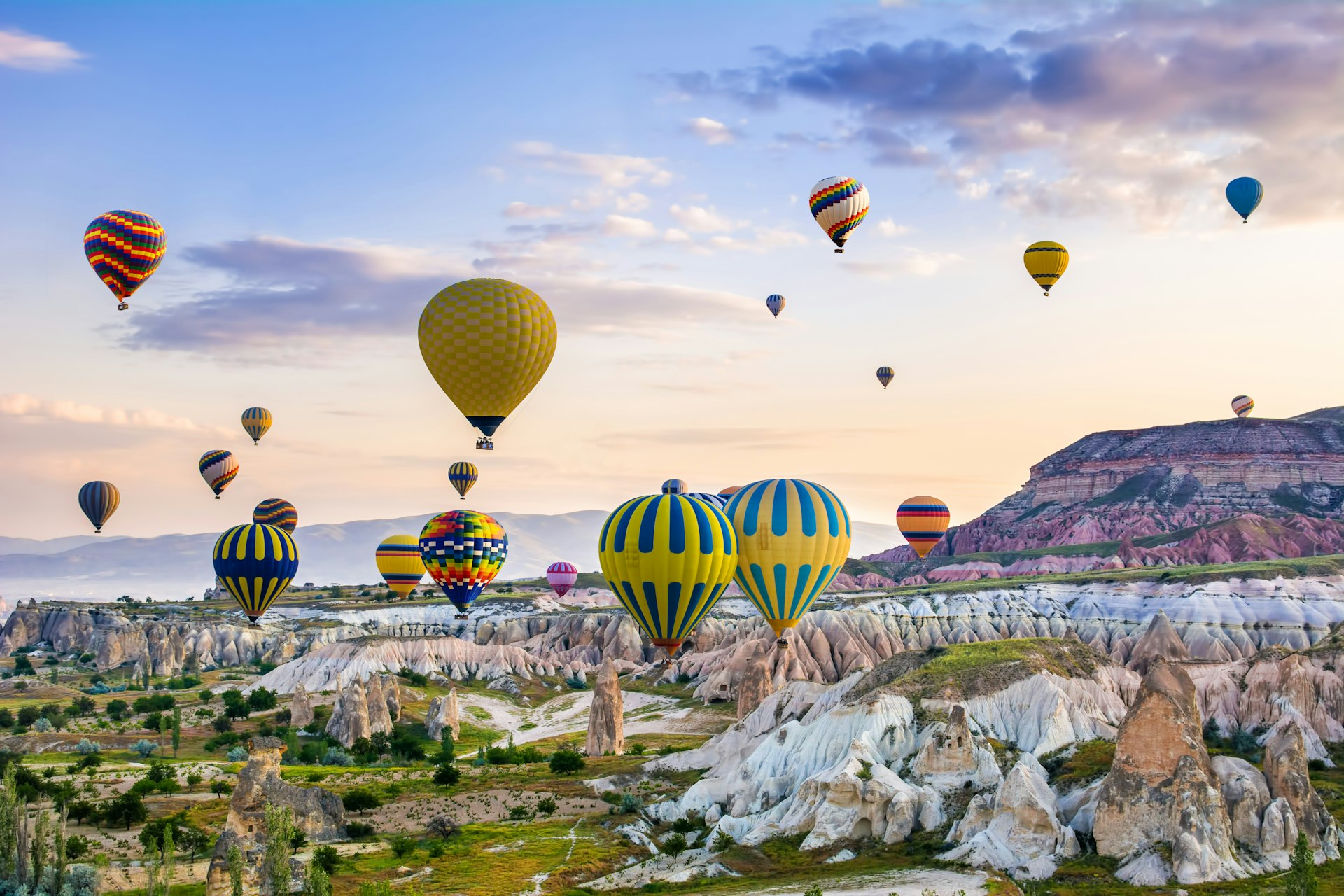 Balloons floating over a rocky landscape at Goreme, Cappadocia