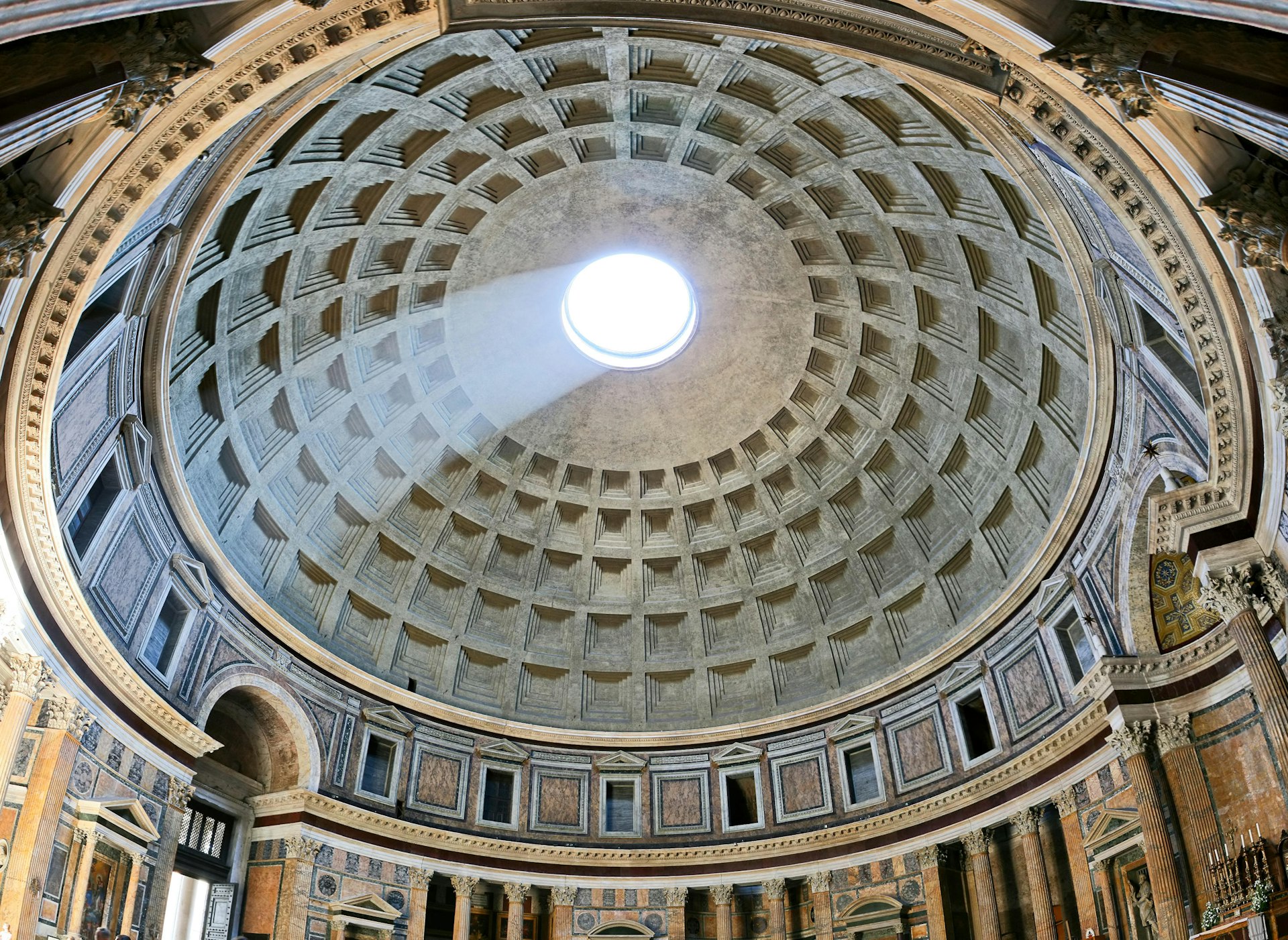 A beam of light shines through the oculus of the dome at the Pantheon, in Rome