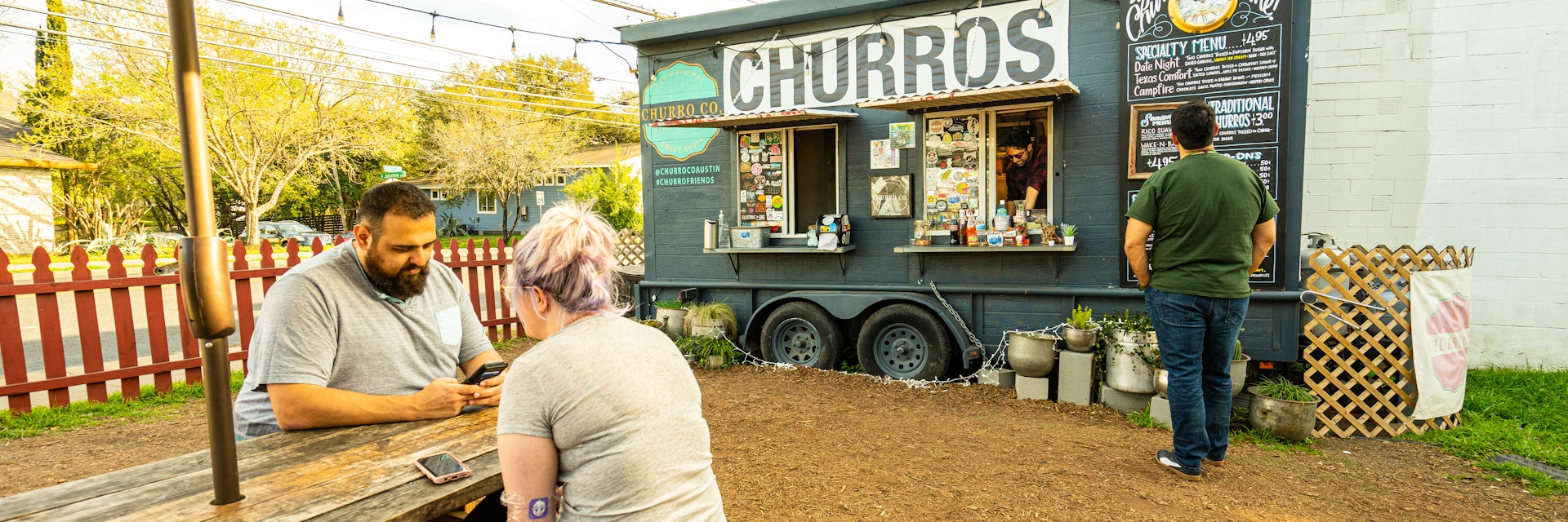 AUSTIN - CIRCA MAY 2019: People eat at a local food truck called Austin Churro Co. in east Austin, Texas. The food truck a wide variety of delicious desserts.