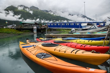 Double kayaks parked on the pier on scenic mountain ocean bay in Valdez, Alaska