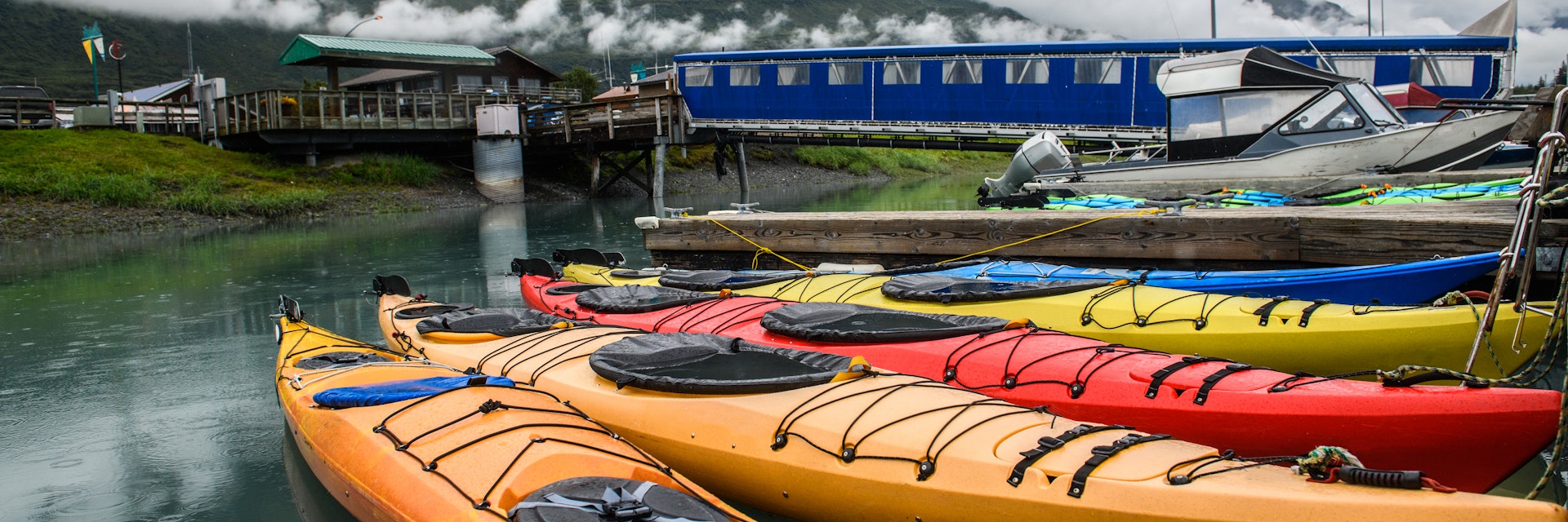 Double kayaks parked on the pier on scenic mountain ocean bay in Valdez, Alaska