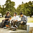 Group of laughing male and female skateboarders hanging out in neighborhood skate park in Seattle