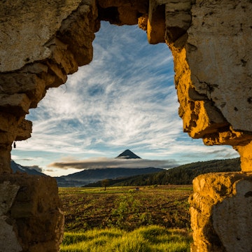 A volcano in Quetzaltenango, Guatemala through a hole in a brick wall.