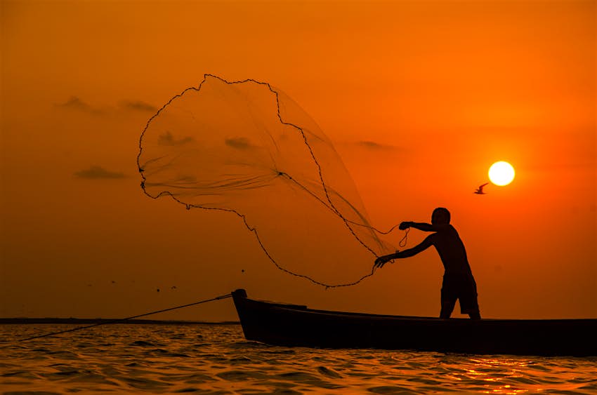 Silhouette of a fisherman casting his net in Guatemala