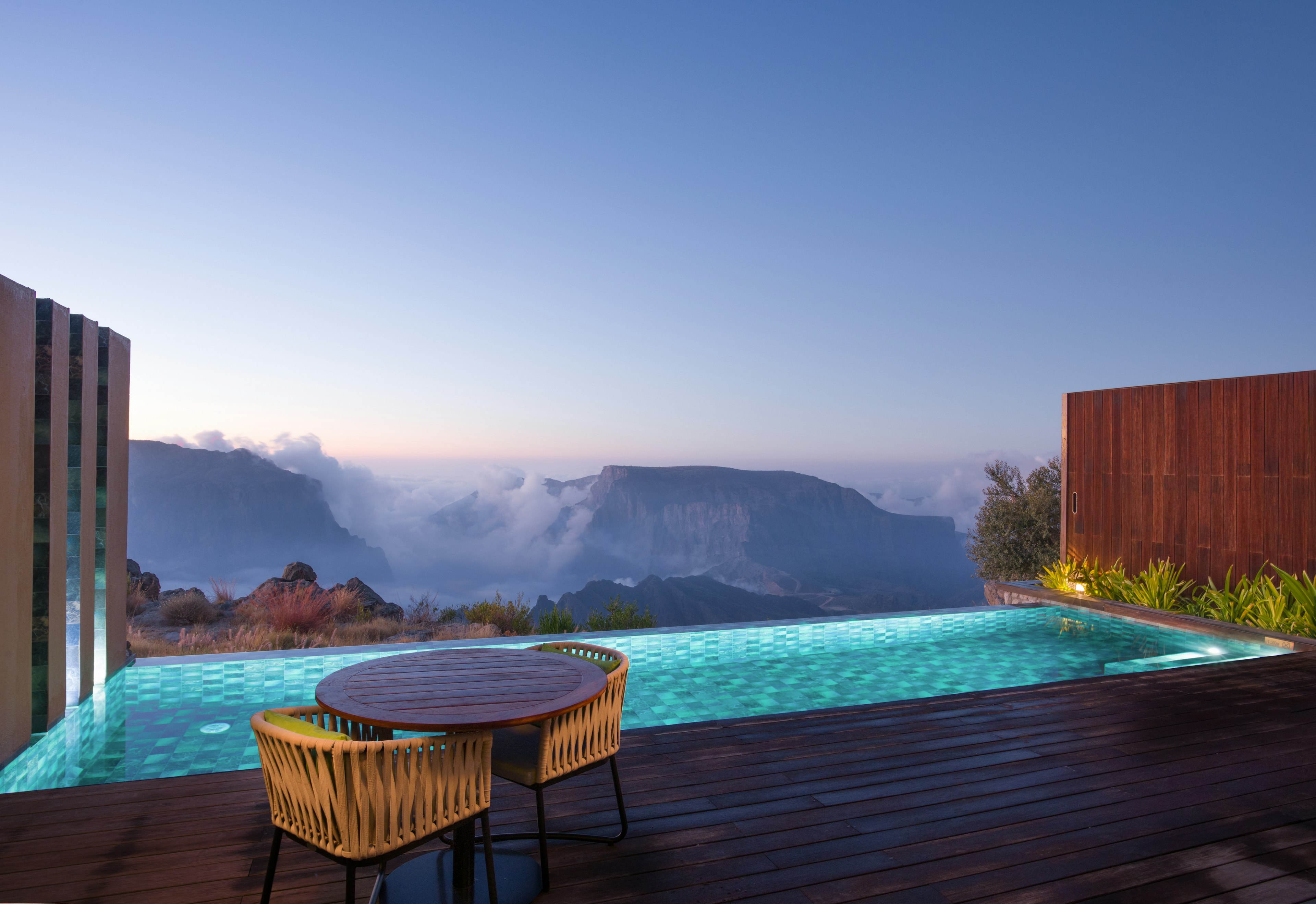 A private pool next to decking, with mountains in the distance