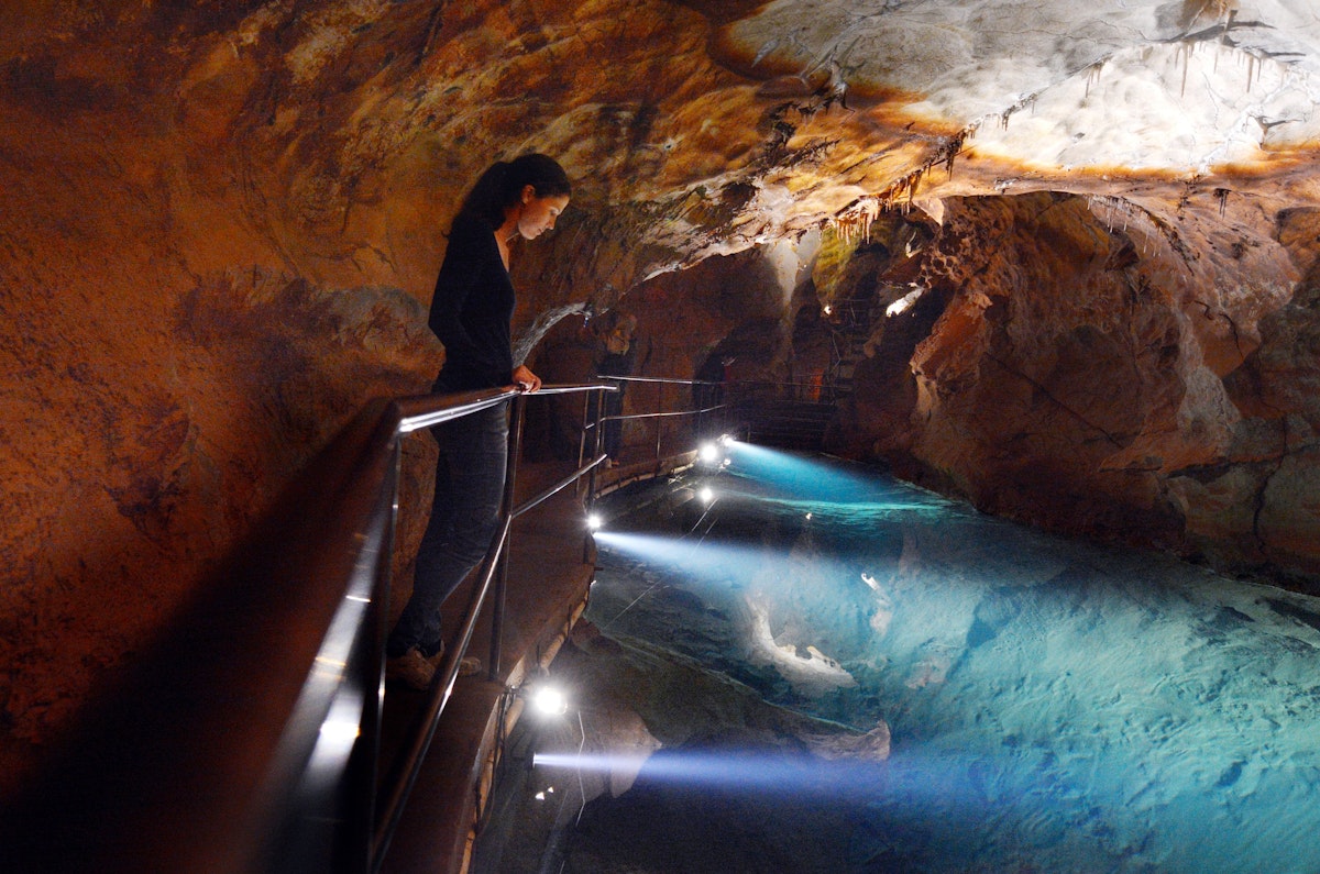 Woman looks at the water pool in River Cave at the Jenolan Caves at the Blue Mountains of New South Wales, Australia.